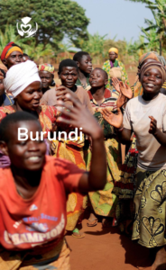 Exuberant Burundian children and adults celebrate with traditional dance, with the Global Care Alliance logo visible