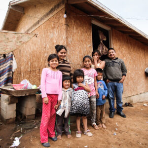 A family stands together outside their home in a Mexican village